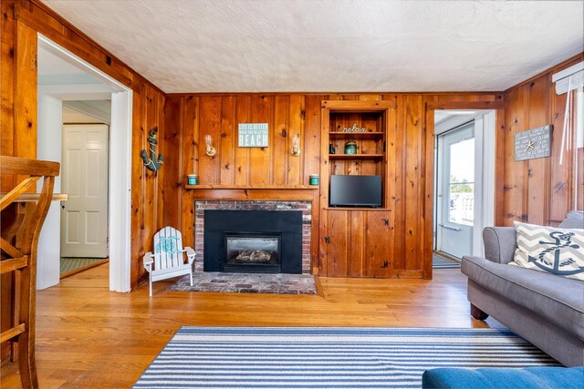 1006 Craigville Beach Rd Unit 4, Centerville, MA 02632 - living room with wood walls, a brick fireplace, and wood finished floors