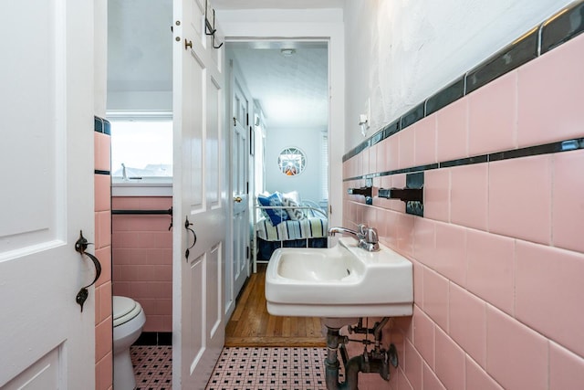 1006 Craigville Beach Rd Unit 4, Centerville, MA 02632 - bathroom featuring tile walls, toilet, a sink, and tile patterned floors