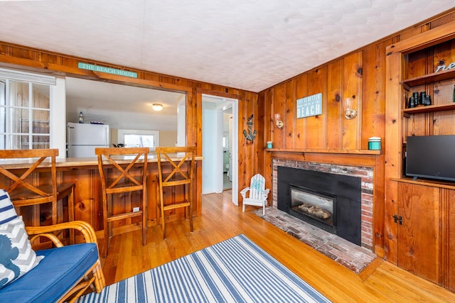 1006 Craigville Beach Rd Unit 4, Centerville, MA 02632 - living room with wooden walls, a brick fireplace, and wood finished floors