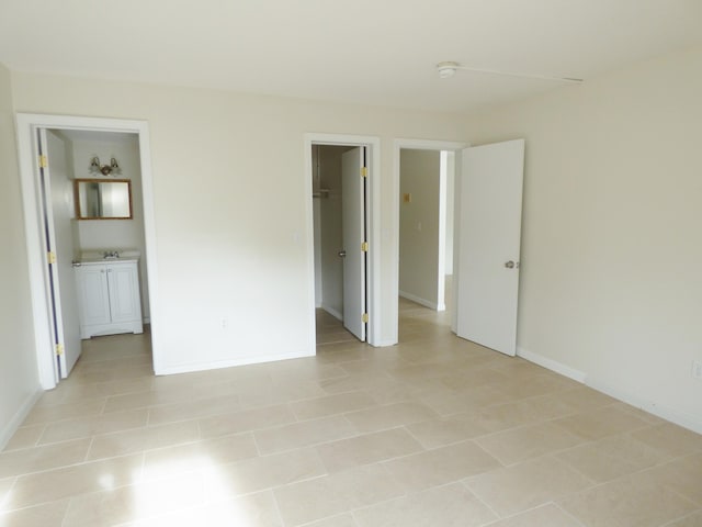 15 Oak Neck Rd Unit 2 12, Hyannis, MA 02601 - unfurnished bedroom featuring a closet, connected bathroom, light tile patterned floors, and a walk in closet