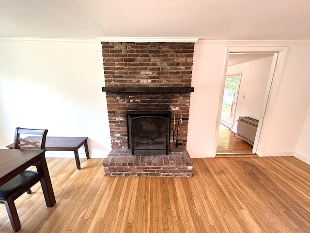 12 Amelia Way S, Yarmouth, MA 02664 - unfurnished living room with a brick fireplace, wood finished floors, an AC wall unit, and ornamental molding