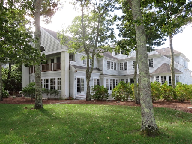 view of front facade with a front yard and a balcony