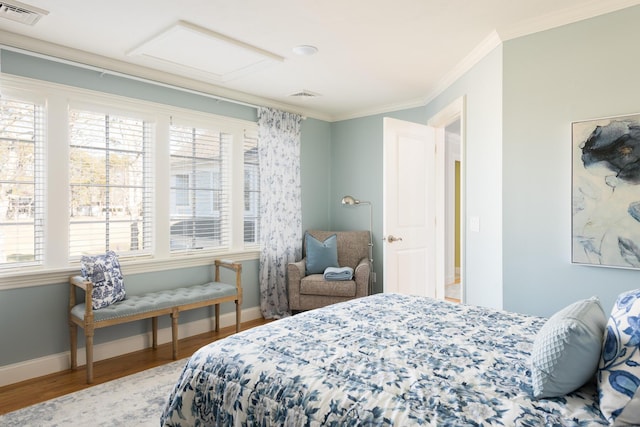 bedroom with visible vents, multiple windows, attic access, and crown molding