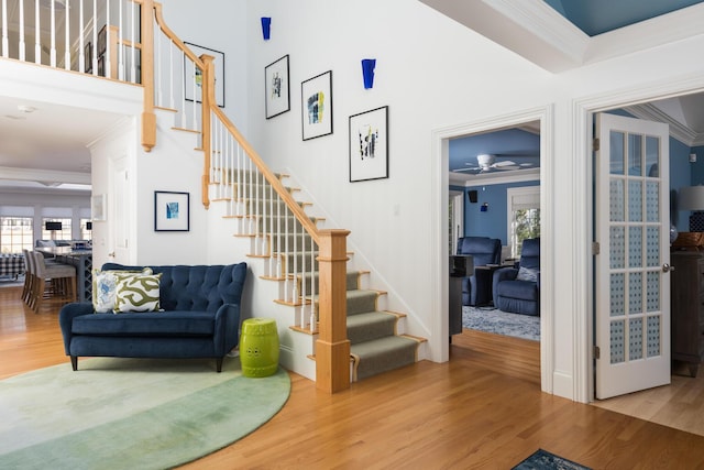 stairway featuring crown molding and wood finished floors