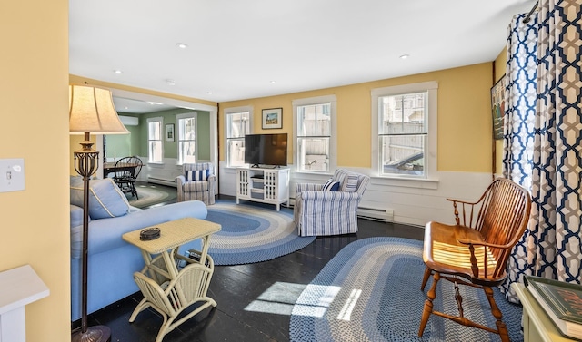 living area featuring recessed lighting, baseboard heating, wainscoting, and wood finished floors