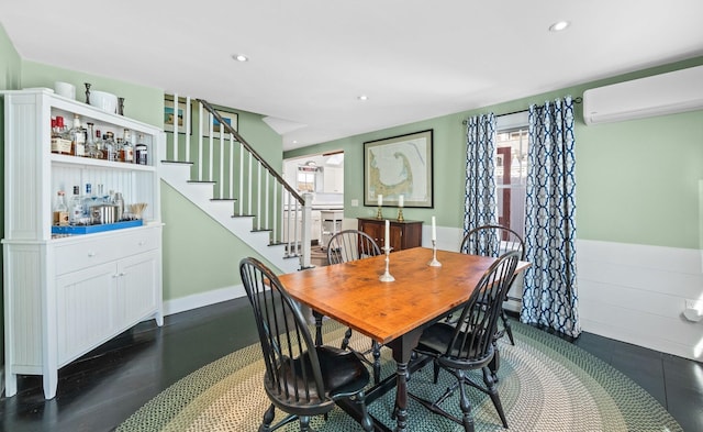 dining room with an AC wall unit, recessed lighting, baseboards, a dry bar, and stairs