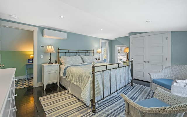 bedroom featuring dark wood-type flooring, baseboards, a wall mounted air conditioner, recessed lighting, and a closet