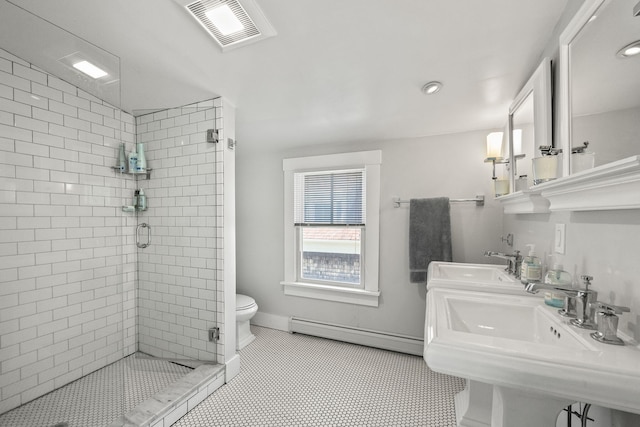 full bath with visible vents, a stall shower, dual sinks, a baseboard radiator, and baseboards