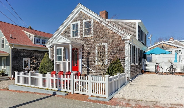 view of front facade with a fenced front yard and a chimney