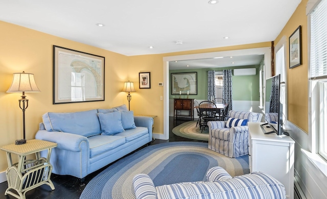 living room with recessed lighting, baseboards, a wall unit AC, and wood finished floors