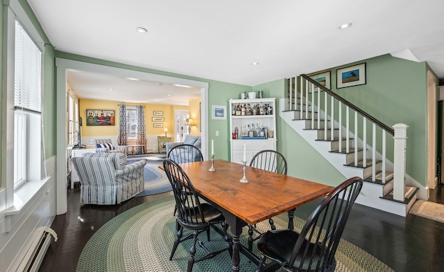 dining area featuring stairway, wood finished floors, recessed lighting, a dry bar, and baseboard heating