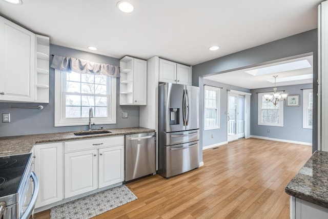 kitchen with stainless steel appliances, light wood-style floors, white cabinetry, open shelves, and a sink