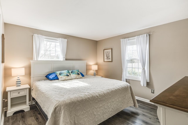 bedroom with dark wood-type flooring and baseboards