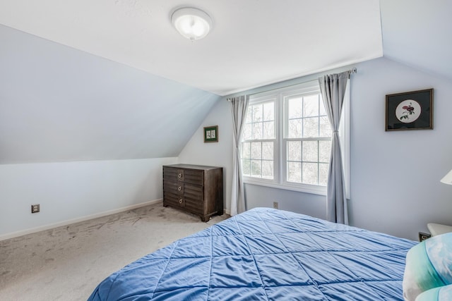 bedroom with light carpet, baseboards, and lofted ceiling