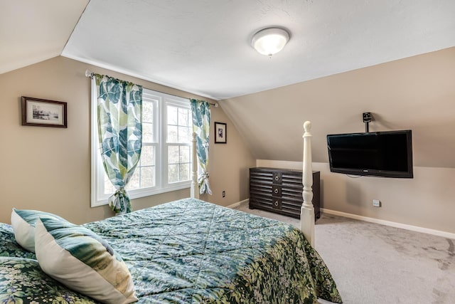 bedroom with lofted ceiling, carpet, and baseboards