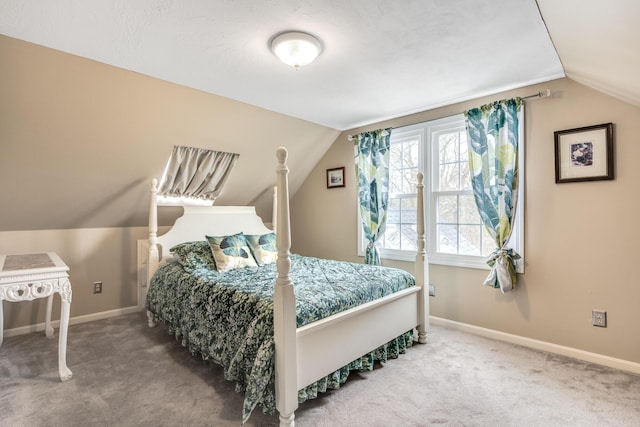 carpeted bedroom featuring lofted ceiling and baseboards