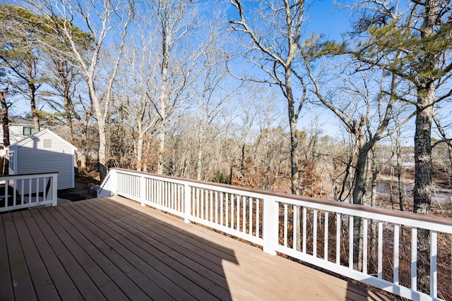 wooden terrace with a storage shed and an outbuilding