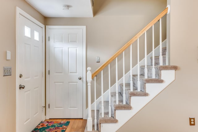 foyer entrance with stairs and wood finished floors