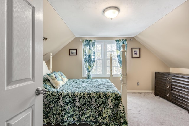 bedroom featuring light carpet, lofted ceiling, and baseboards