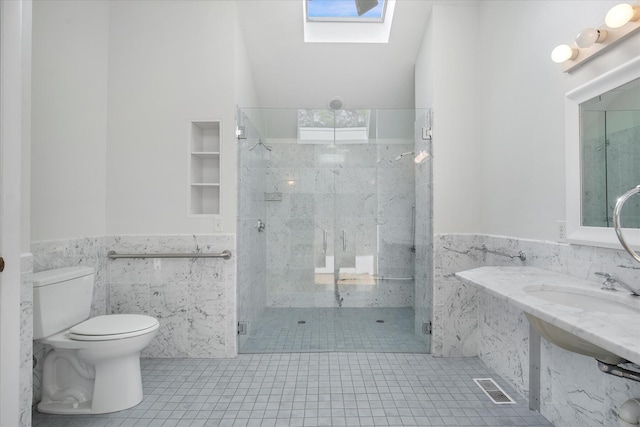 174 Waterway, Mashpee, MA 02649 - full bath with tile walls, a skylight, tile patterned floors, a wainscoted wall, and toilet