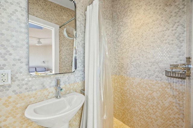 bathroom featuring sink, decorative backsplash, and a shower