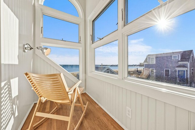 sunroom featuring a water view