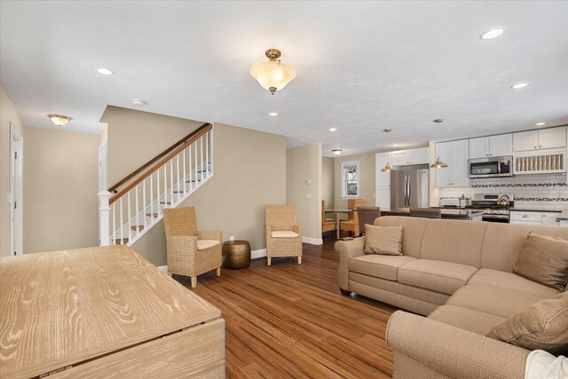 staircase with wood finished floors and recessed lighting