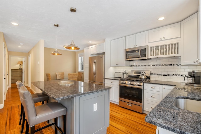 9 Country Ln, Dennis Port, MA 02639 - kitchen featuring stainless steel appliances, a center island, a breakfast bar, backsplash, and recessed lighting