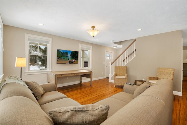 living area with stairway, wood finished floors, and a healthy amount of sunlight