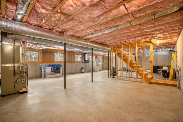 basement with heating unit and stairway