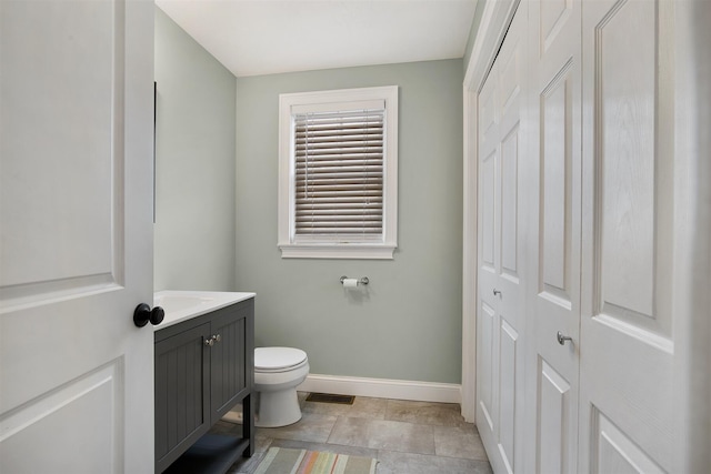 bathroom with toilet, baseboards, visible vents, and vanity