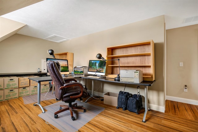 office featuring attic access, baseboards, visible vents, lofted ceiling, and wood finished floors