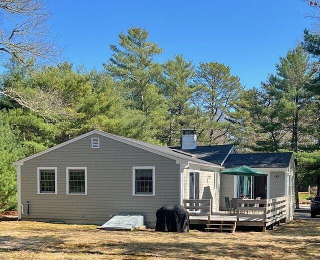back of house featuring a chimney and a deck