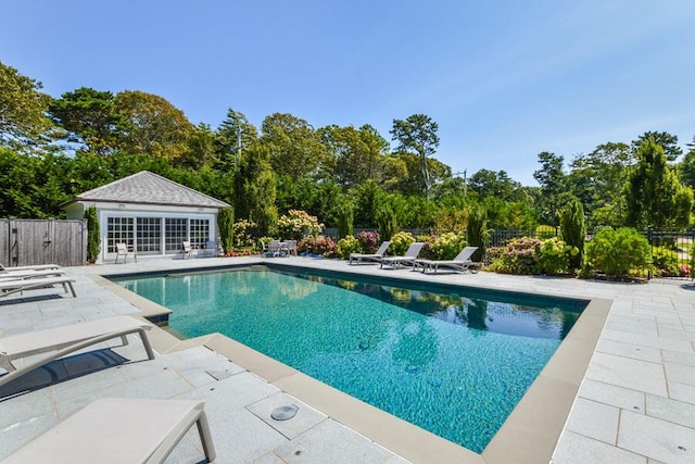 view of swimming pool with a patio and an outbuilding