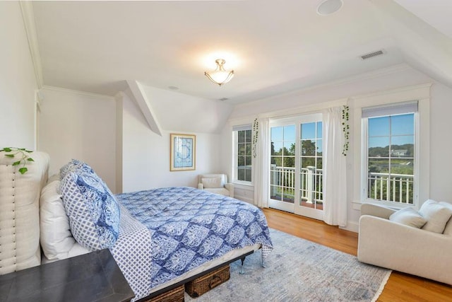 bedroom with wood-type flooring, crown molding, lofted ceiling, and access to outside