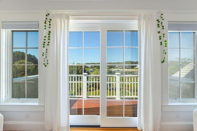 entryway featuring a healthy amount of sunlight and crown molding