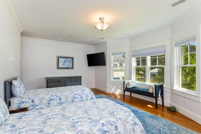 bedroom with hardwood / wood-style flooring and ornamental molding