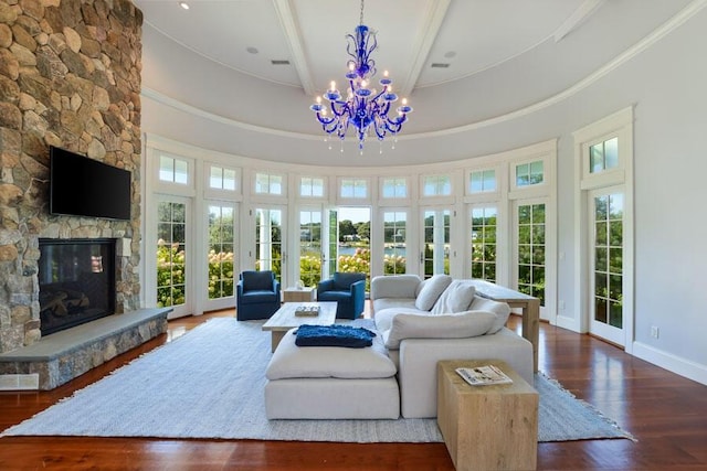 living room with a fireplace, dark wood-type flooring, a notable chandelier, and ornamental molding