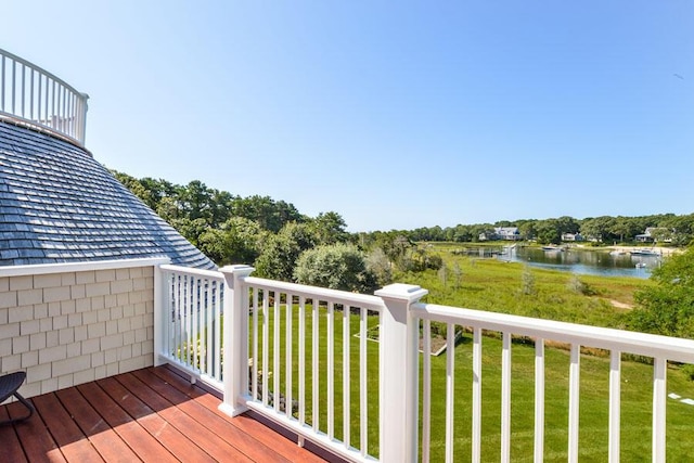 deck with a water view and a lawn