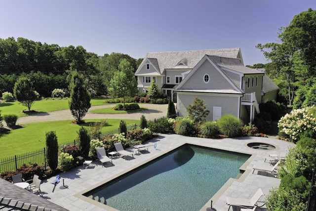 view of swimming pool featuring an in ground hot tub, a patio area, and a yard