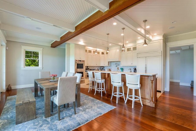 dining space with dark hardwood / wood-style flooring and beamed ceiling