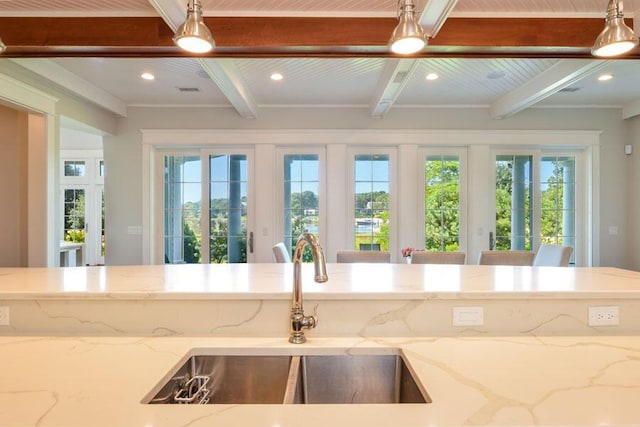 kitchen with sink, beam ceiling, light stone countertops, and wooden ceiling