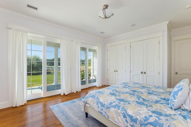 bedroom with hardwood / wood-style flooring, access to exterior, and crown molding