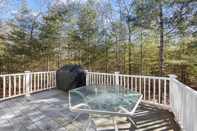 wooden deck featuring outdoor dining area and a grill