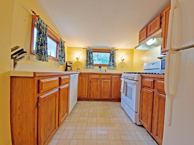 15 Fir St, Wareham, MA 02571 - kitchen with white appliances, under cabinet range hood, brown cabinetry, light countertops, and brick patterned floors