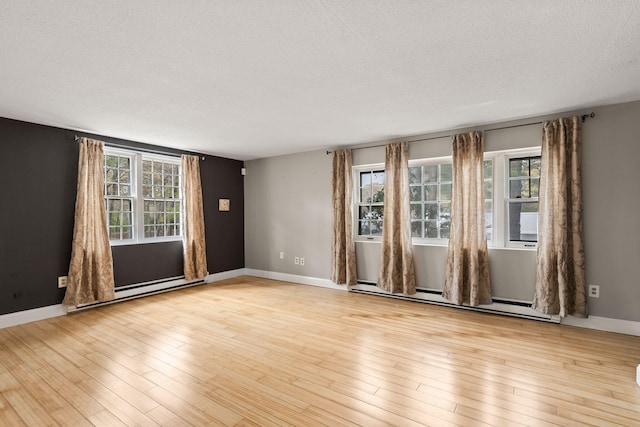 733 W Main St Unit G, Barnstable, MA 02630 - spare room featuring a baseboard heating unit, healthy amount of natural light, a textured ceiling, baseboard heating, and light wood-style floors
