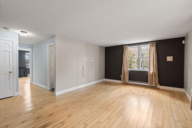 733 W Main St Unit G, Barnstable, MA 02630 - spare room featuring baseboard heating, light wood-style flooring, baseboards, a smoke detector, and a textured ceiling