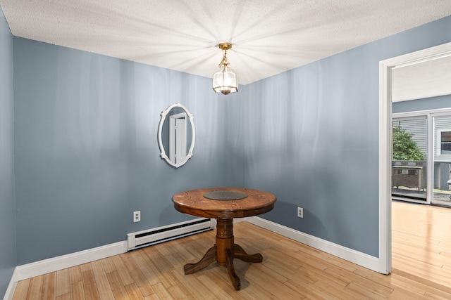 733 W Main St Unit G, Barnstable, MA 02630 - unfurnished dining area with a baseboard heating unit, baseboards, wood finished floors, and a textured ceiling