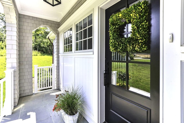 doorway to outside featuring a healthy amount of sunlight and crown molding