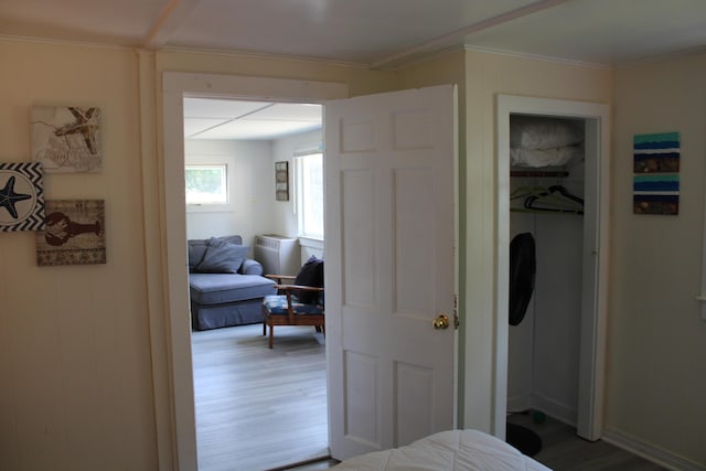 bedroom with crown molding, hardwood / wood-style flooring, and a closet